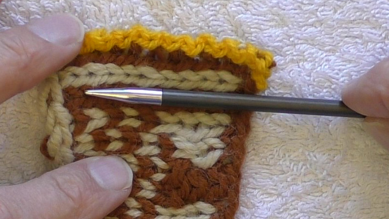 Pointing to the line of edge stitches to be picked up.