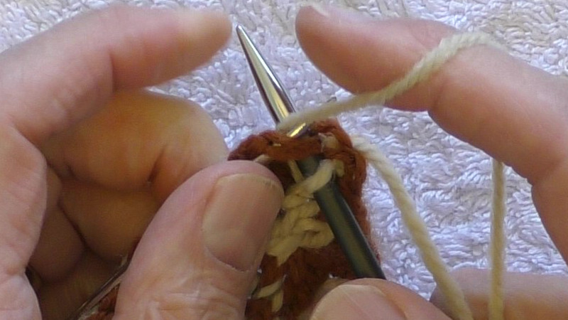 Right needle inserted knitwise and yarn being wrapped around it.