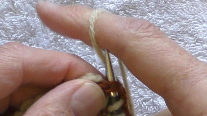 Yarn being wrapped knitwise around the right hand needle.